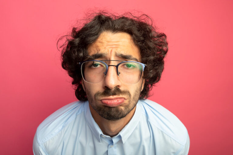 close-up-view-sad-young-handsome-man-wearing-glasses-looking-front-isolated-pink-wall