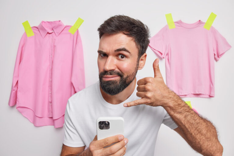 איש מוזר מחזיק סלולרי ברקע שתי חולצות ורודות